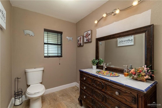 bathroom featuring vanity, wood-type flooring, and toilet