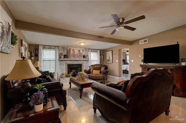 living room with plenty of natural light, ceiling fan, beam ceiling, and a brick fireplace