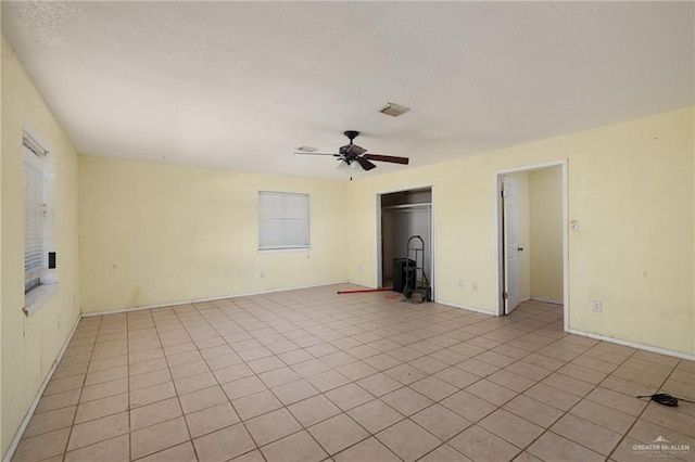 spare room featuring ceiling fan and light tile patterned flooring