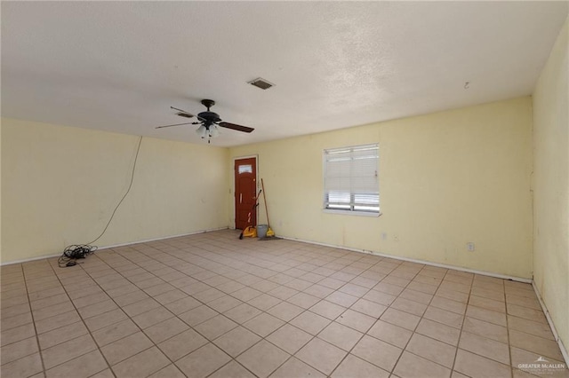 empty room with light tile patterned floors and ceiling fan