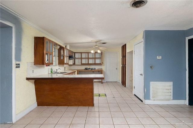 kitchen featuring sink, crown molding, ceiling fan, light tile patterned floors, and kitchen peninsula