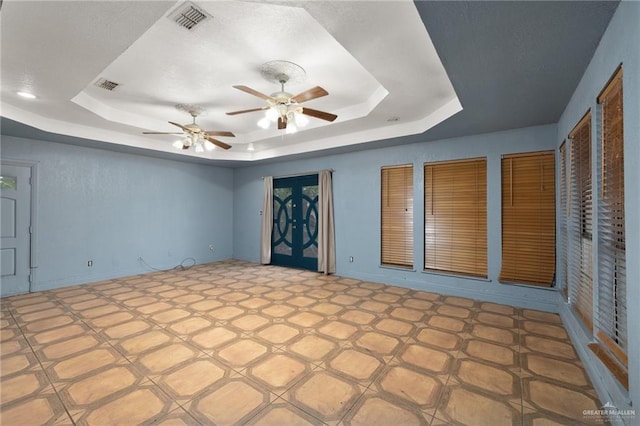 interior space featuring ceiling fan and a raised ceiling