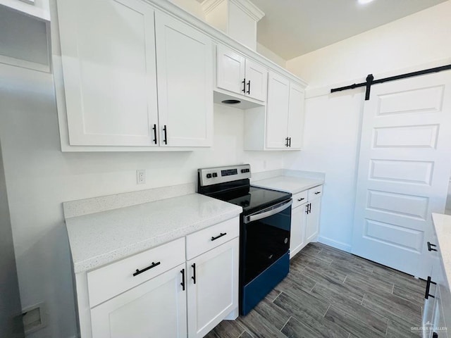 kitchen with white cabinetry, a barn door, and stainless steel electric range oven