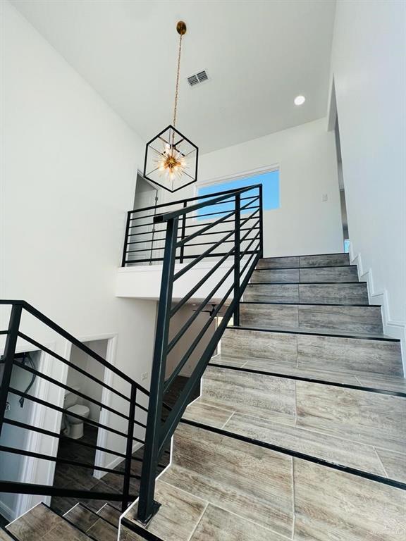 stairs with a chandelier