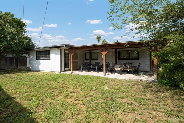 rear view of property with a lawn and a patio