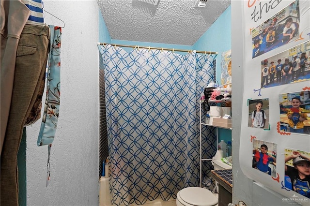 bathroom with a shower with curtain, toilet, and a textured ceiling