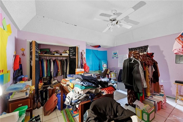 bedroom featuring light tile patterned floors, a textured ceiling, a closet, and ceiling fan