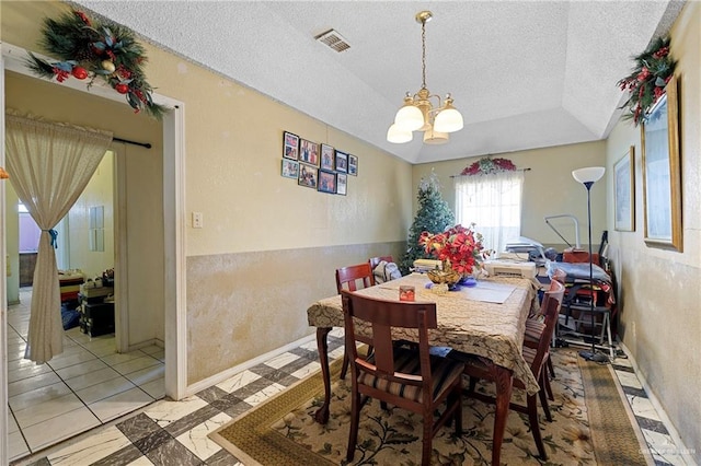 dining room with a chandelier and a textured ceiling