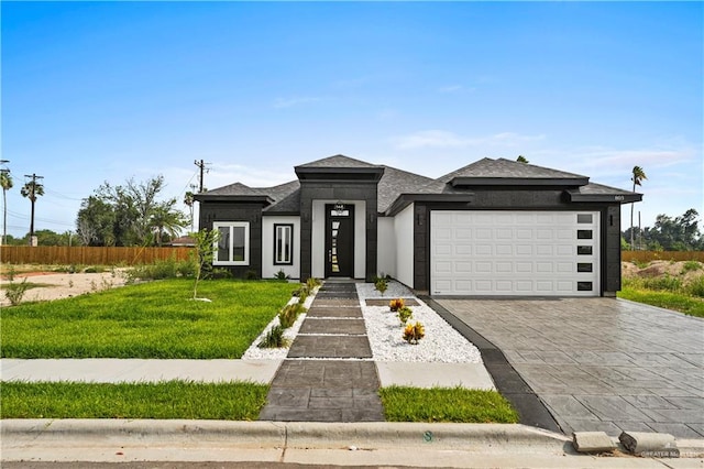 prairie-style house with a garage and a front lawn