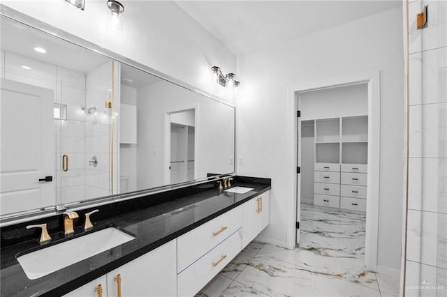 bathroom featuring a shower with door and vanity