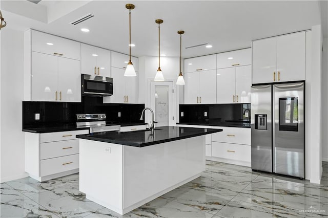 kitchen featuring white cabinets, sink, decorative backsplash, an island with sink, and stainless steel appliances