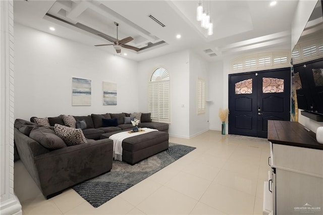 living area featuring a tray ceiling, a ceiling fan, visible vents, and recessed lighting