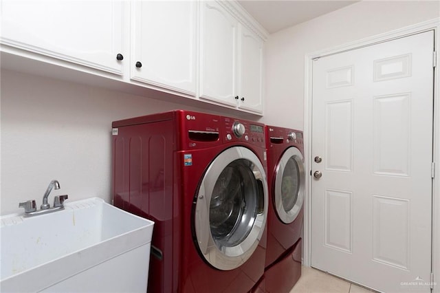 laundry area featuring light tile patterned flooring, cabinets, sink, and washing machine and dryer