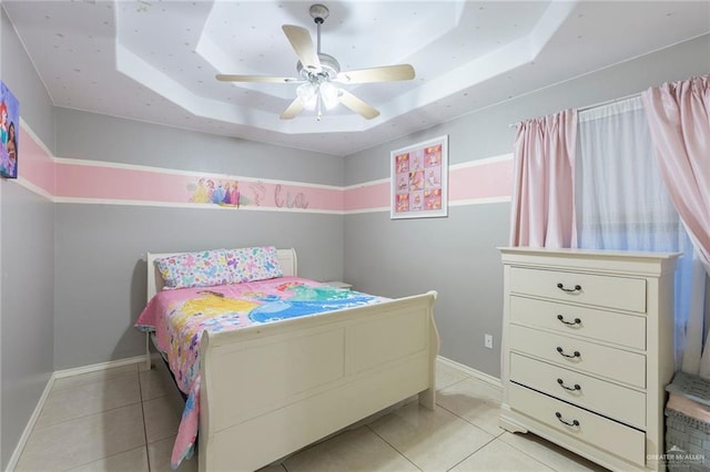 bedroom with light tile patterned floors, a raised ceiling, and ceiling fan