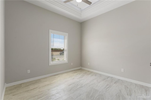 spare room with ceiling fan, ornamental molding, and a tray ceiling