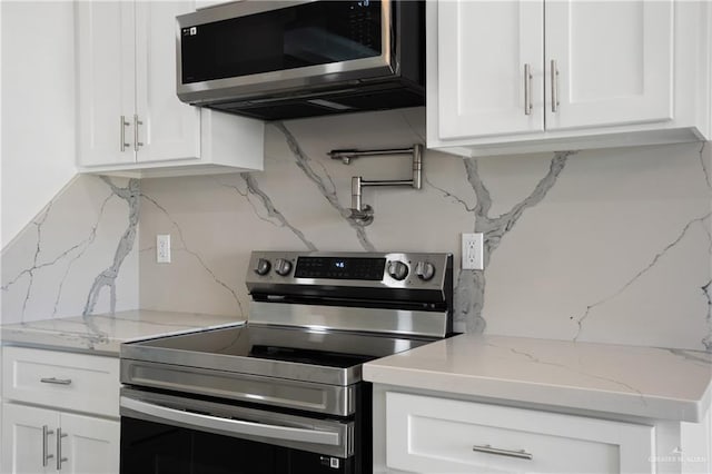 kitchen featuring tasteful backsplash, white cabinetry, and appliances with stainless steel finishes