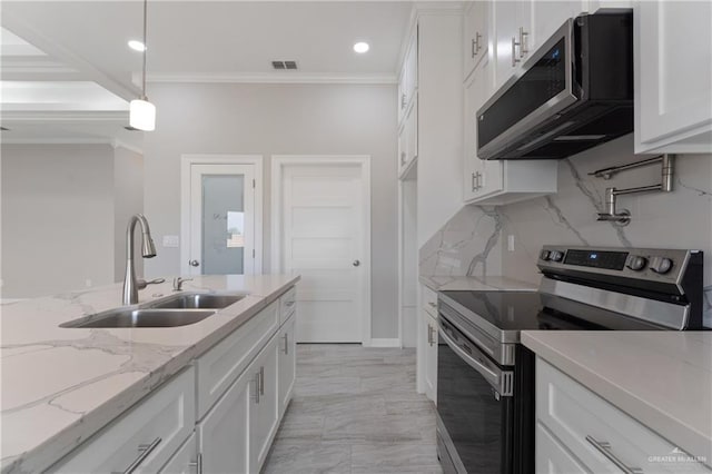 kitchen with sink, light stone countertops, appliances with stainless steel finishes, decorative light fixtures, and white cabinetry