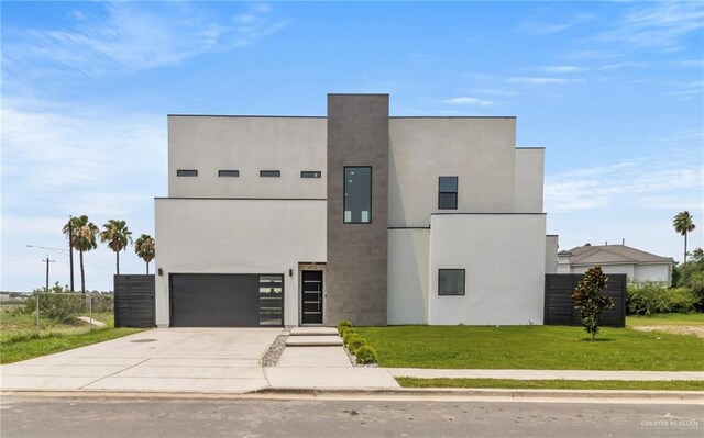 contemporary house with a front lawn, driveway, stucco siding, and an attached garage