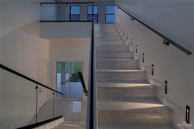stairway featuring a high ceiling