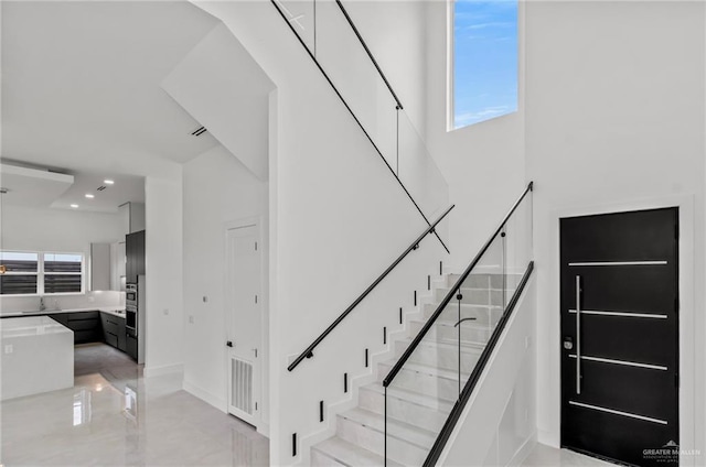 stairway featuring plenty of natural light, visible vents, and recessed lighting