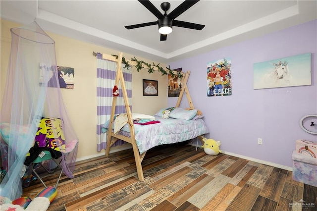 bedroom featuring hardwood / wood-style floors, a tray ceiling, and ceiling fan