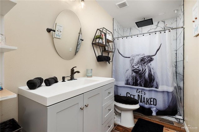 bathroom featuring hardwood / wood-style flooring, vanity, curtained shower, and toilet