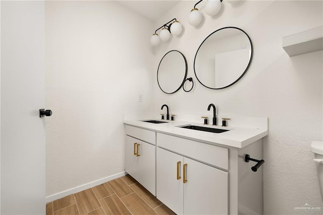 112 Tecate Dr, Mission, TX 78572 - bathroom featuring wood finish floors, baseboards, and double vanity