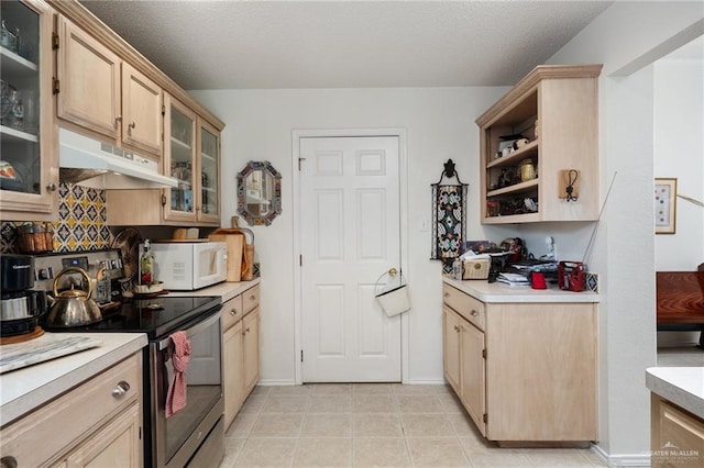 kitchen with light brown cabinetry and stainless steel range with electric stovetop