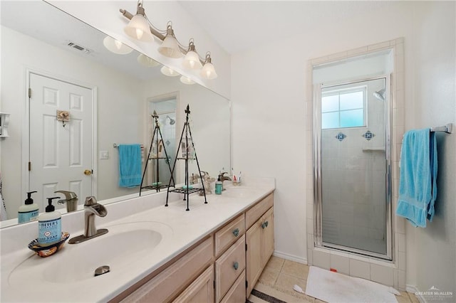 bathroom with tile patterned floors, vanity, and a shower with shower door