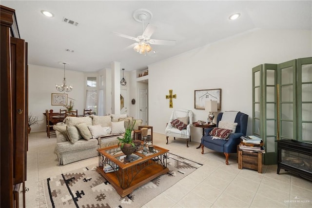 living room with light tile patterned floors, ceiling fan with notable chandelier, a wood stove, and vaulted ceiling