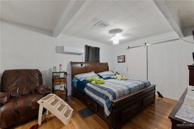 15668 Primera Rd, Harlingen, TX 78552 - bedroom with beamed ceiling, wood finished floors, and an AC wall unit