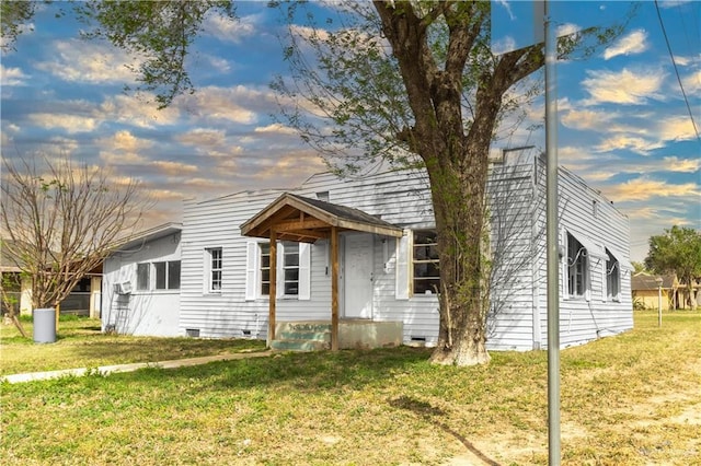 view of front facade with crawl space and a front lawn