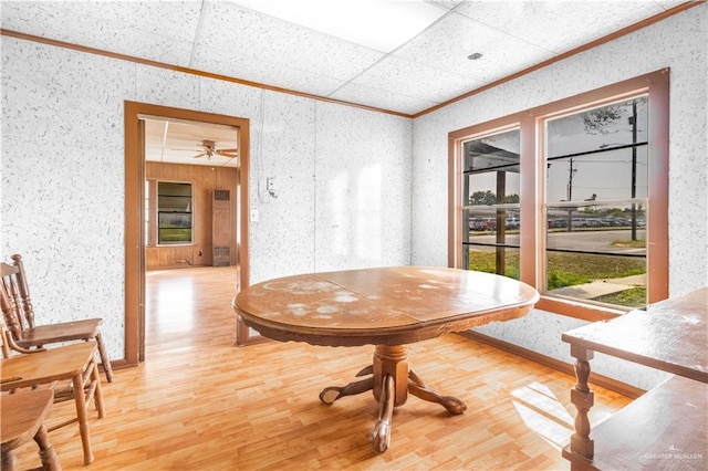 dining room with wallpapered walls, light wood finished floors, and ornamental molding