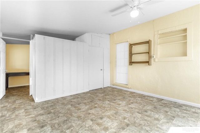 empty room featuring tile patterned floors, a ceiling fan, and baseboards