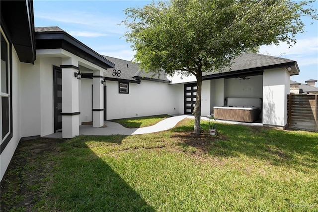 2306 Supreme Dr, Edinburg, TX 78542 - rear view of property with a hot tub, stucco siding, a yard, roof with shingles, and a ceiling fan