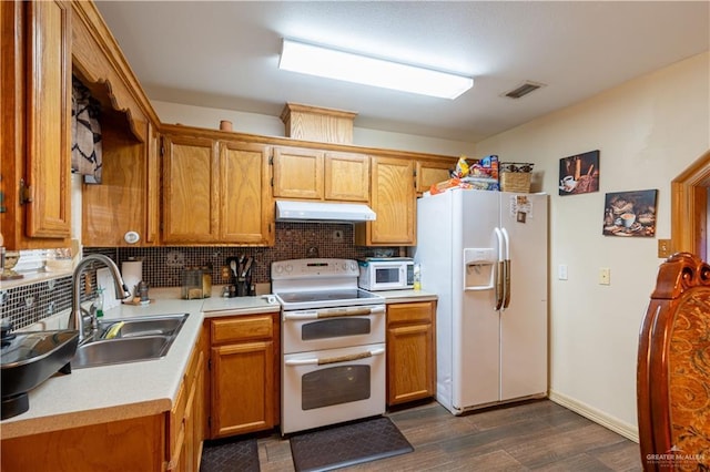 kitchen featuring sink, white appliances, dark wood-type flooring, and backsplash