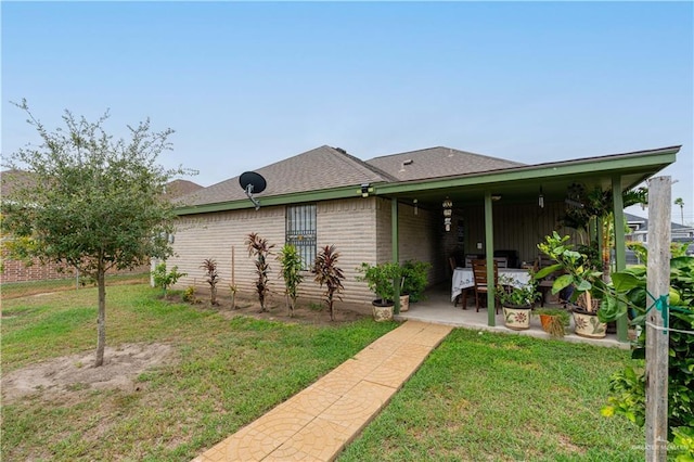 back of property featuring a yard and a patio area