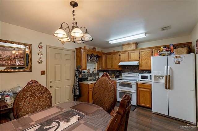 kitchen with pendant lighting, white appliances, backsplash, dark hardwood / wood-style flooring, and a chandelier