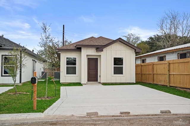 view of front of home featuring a front lawn, a patio, and cooling unit