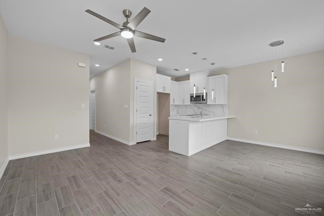 unfurnished living room featuring light hardwood / wood-style flooring, ceiling fan, and sink