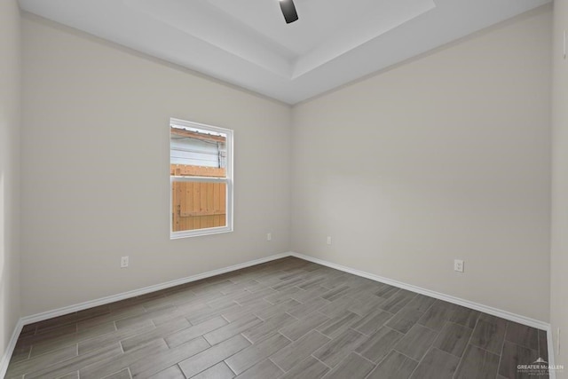 spare room featuring ceiling fan and a tray ceiling