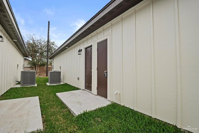 exterior space featuring central air condition unit, a patio area, and a yard