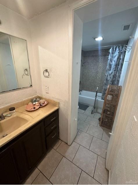 bathroom with tile patterned flooring, shower / bath combination with curtain, and vanity