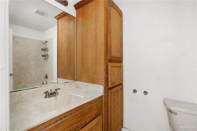 full bathroom featuring vanity, tiled shower / bath combo, and toilet