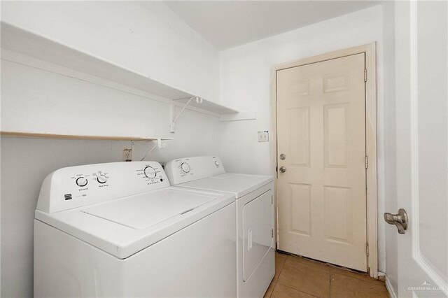 laundry area with washing machine and clothes dryer and light tile patterned flooring