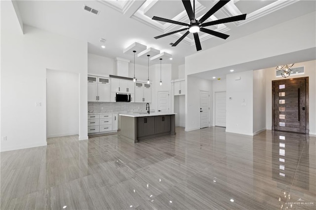 kitchen with open floor plan, stainless steel microwave, a sink, and a ceiling fan