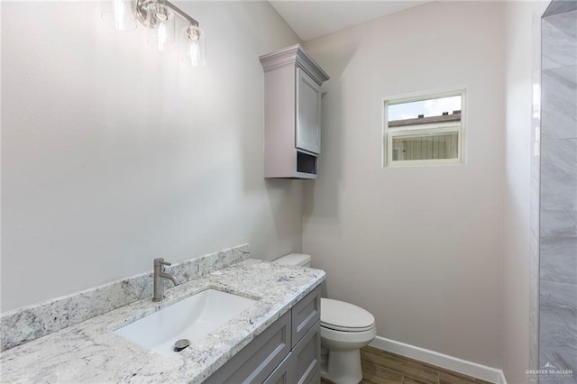 bathroom featuring wood-type flooring, vanity, and toilet