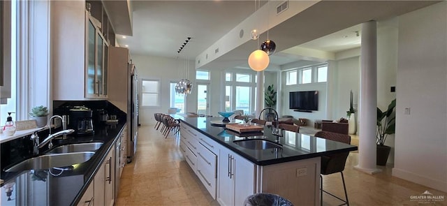 6518 Beach Dr, South Padre Island, TX 78597 - kitchen featuring dark countertops, a sink, a kitchen island with sink, and open floor plan