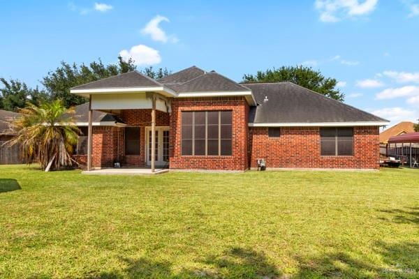 1501 Lookout St, Edinburg, TX 78541 - rear view of property featuring a patio, a yard, and brick siding