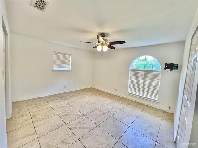 unfurnished room featuring a ceiling fan, baseboards, and visible vents